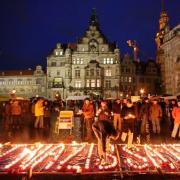 Brennende Kerzen formen den Schriftzug: Diese Stadt hat Nazis satt.