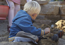 Junge spielt im Sandkasten
