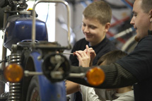 Jugendlicher und Betreuer reparieren ein Moped