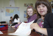 Mädchen mit Down-Syndrom zeigt seine Hausaufgaben