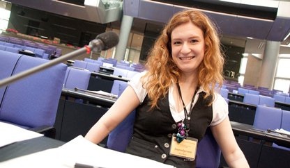 Eine Jugendliche sitzt auf dem Stuhl eine Bundestagsabgeordneten im  Plenarsaal.
