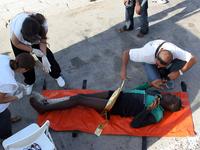 Ärzte helfen einem verletzten und entkräfteten Bootsflüchtling (Foto: AFP)