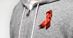 Detailansicht einer roten Schleife an einem grauen Kapuzen-Pullover